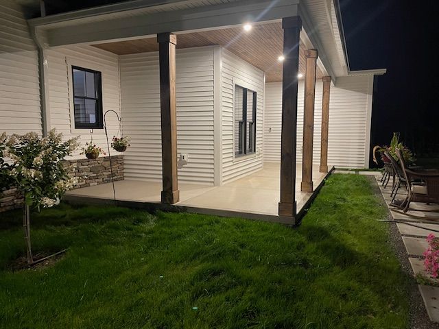 The porch of a house is lit up at night.