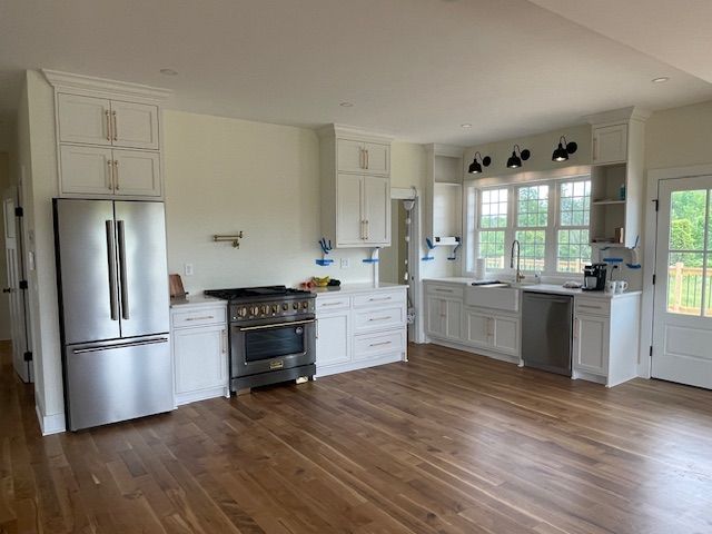 A kitchen under construction with white cabinets and a large island.