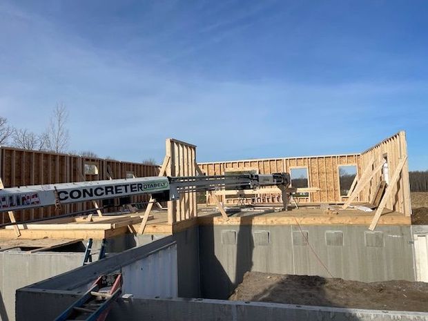 A house is being built with wooden beams and a roof.