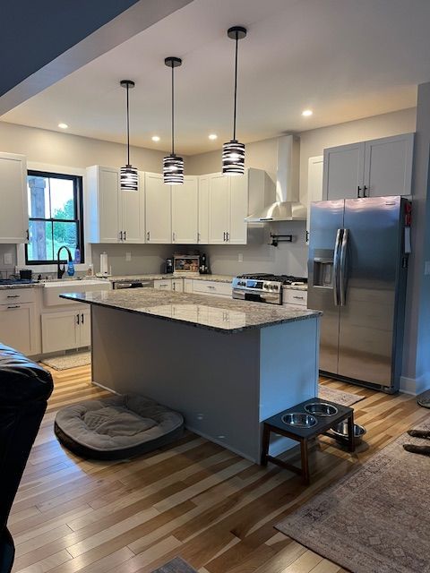A kitchen under construction with white cabinets and a large island.