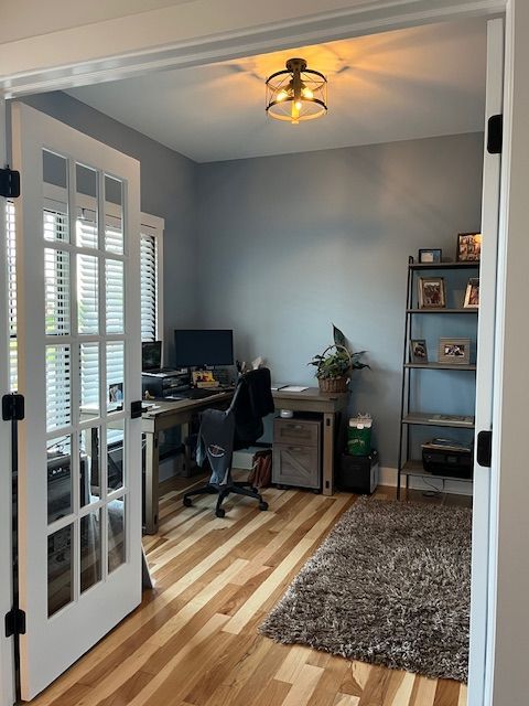 A home office with a desk and chair and a rug