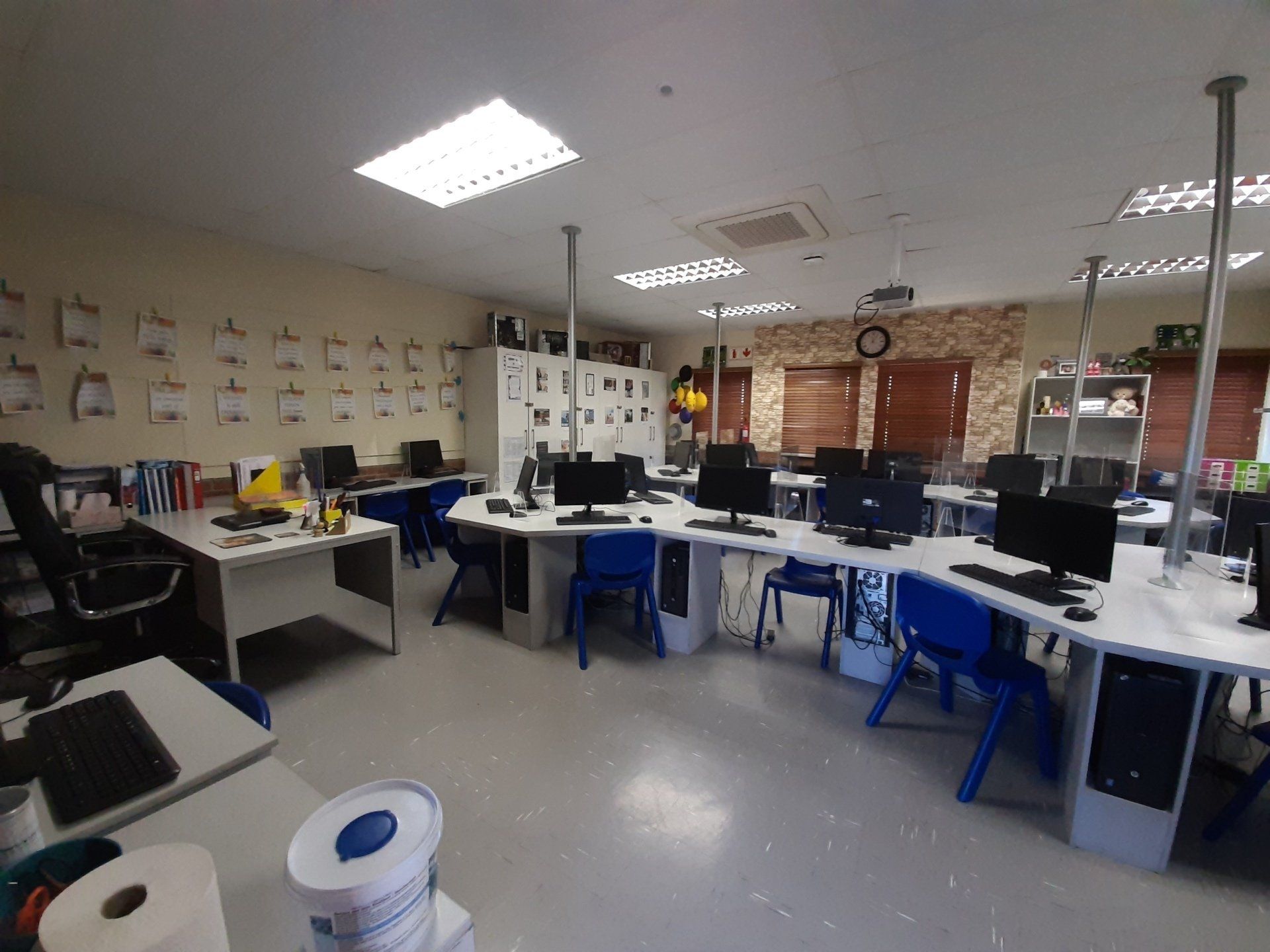 a large room filled with desks and chairs filled with computers .