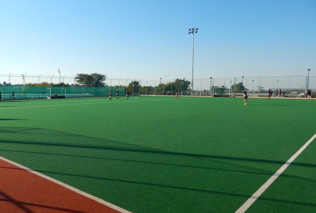 a field hockey game is being played on a sunny day