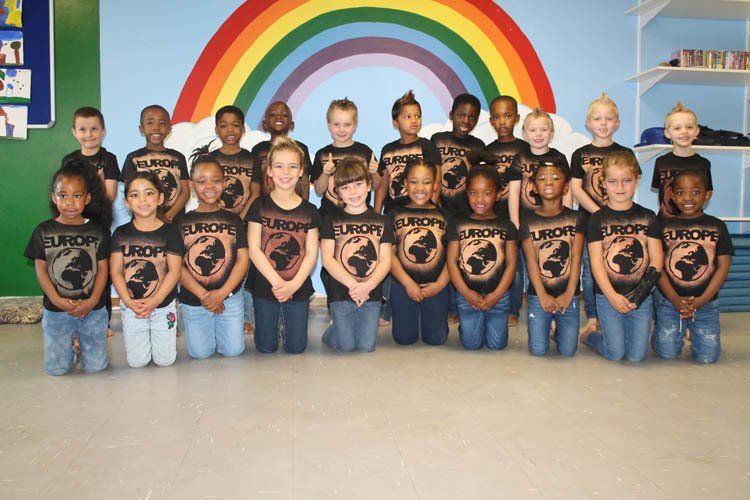 A group of children wearing lunch shirts pose for a picture