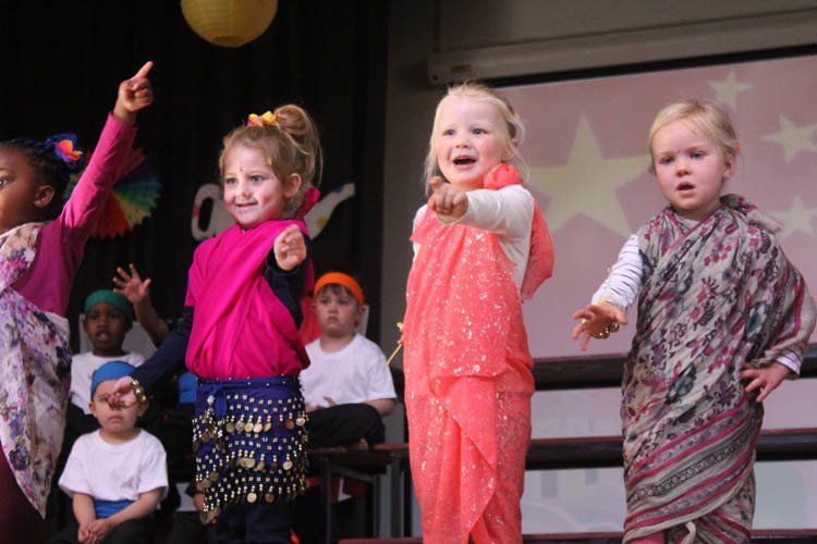 A group of young girls are dancing on a stage.