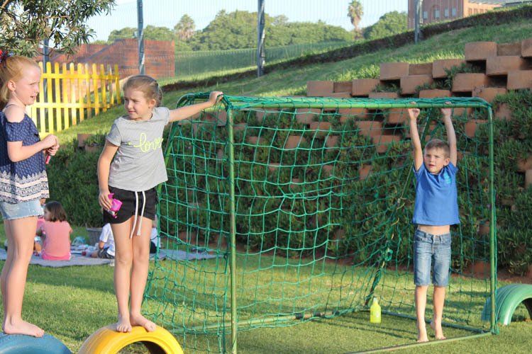 A group of children are playing soccer in a yard.