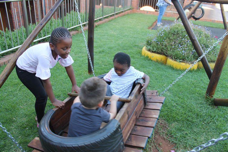 A group of children are playing in a tire swing.