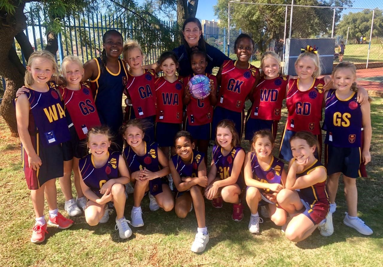 A group of young girls are posing for a picture with their coach.