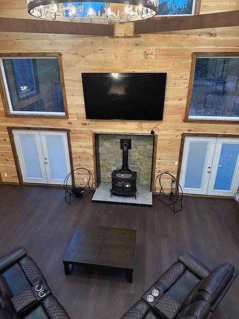 Living room with wood paneling, TV above fireplace, two recliners, and a coffee table.