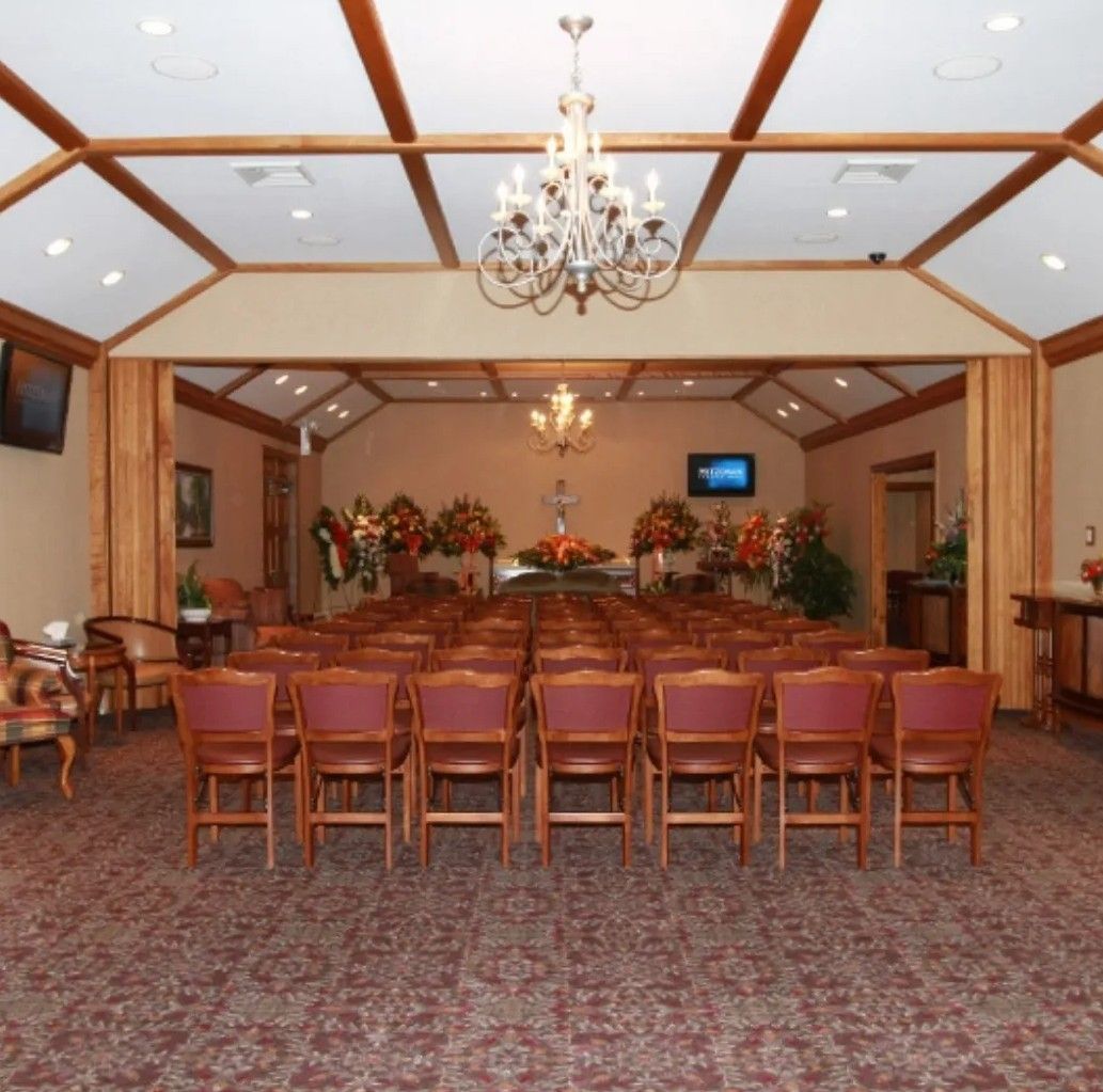 An elderly couple hugging each other on a rooftop at sunset.