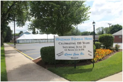 Sign for Hitzman Funeral Home celebrating 110 years. Event on June 21, 12 noon to 4 pm, in front of building with tent.