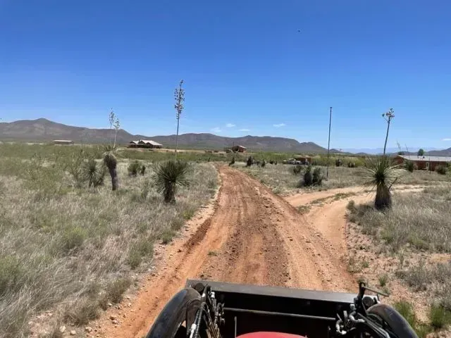 A person is riding a motorcycle down a dirt road.