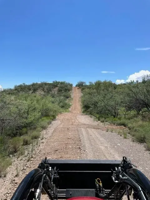 A person is riding a buggy down a dirt road.