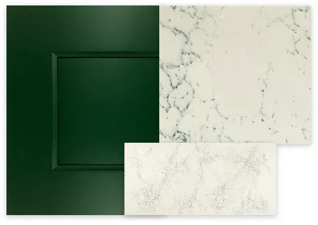 Green cabinet door next to two samples of white quartz countertops with grey veining.