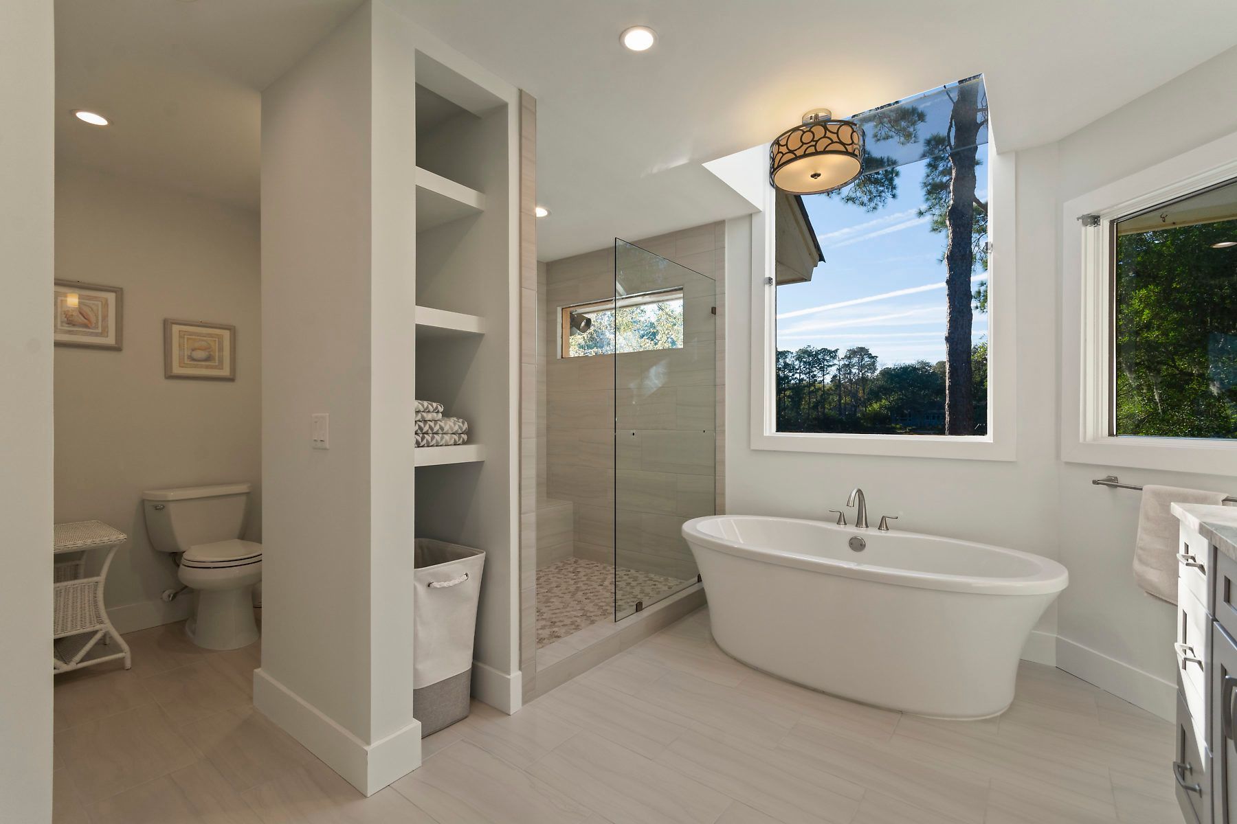 Elegant bathroom with arched window, freestanding tub, and walk-in shower.