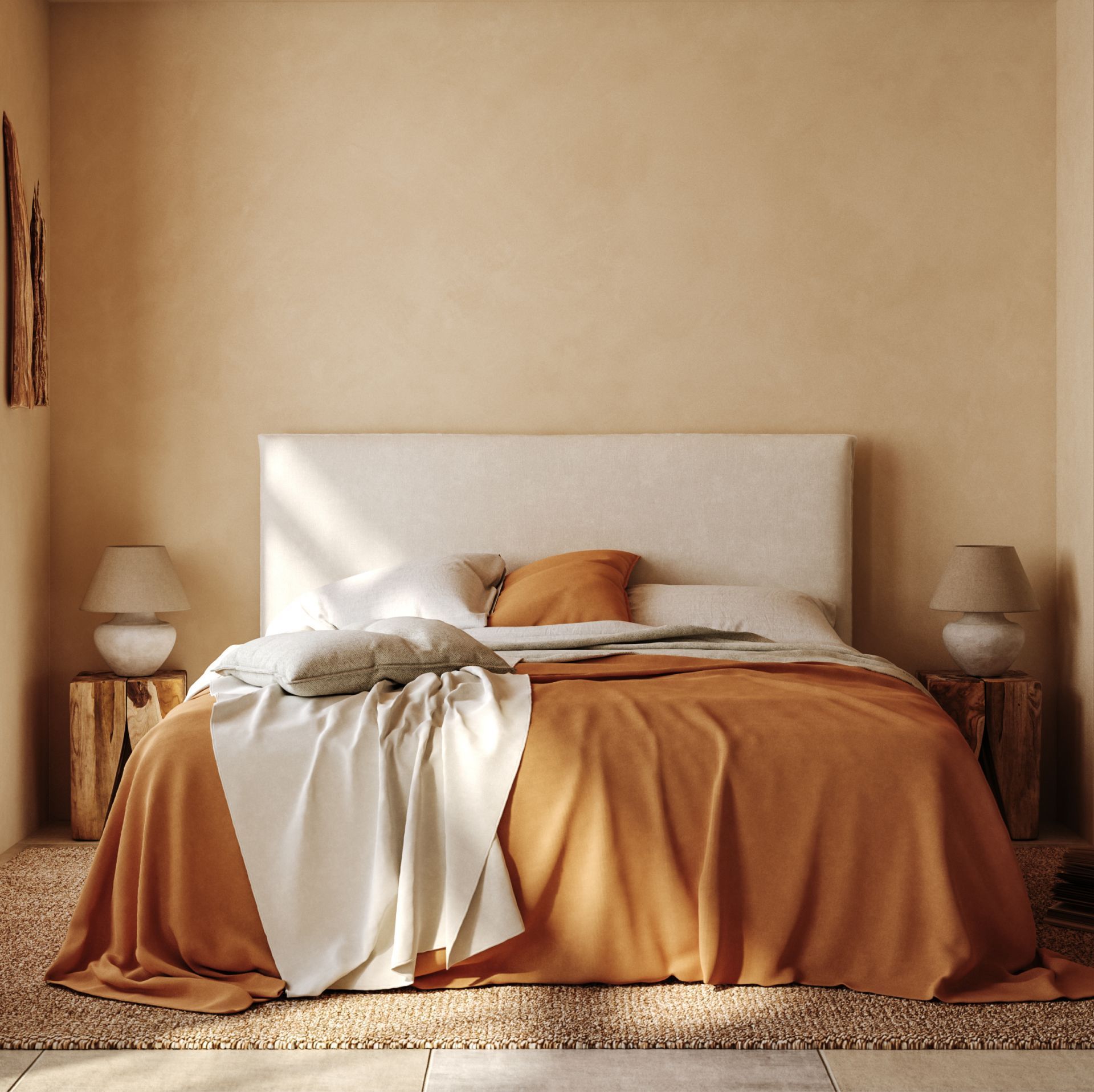 Bedroom with an orange bedspread, off-white headboard, two wooden side tables, and beige walls.