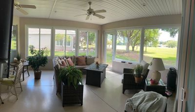 A screened in area with a swimming pool in the backyard of a house.