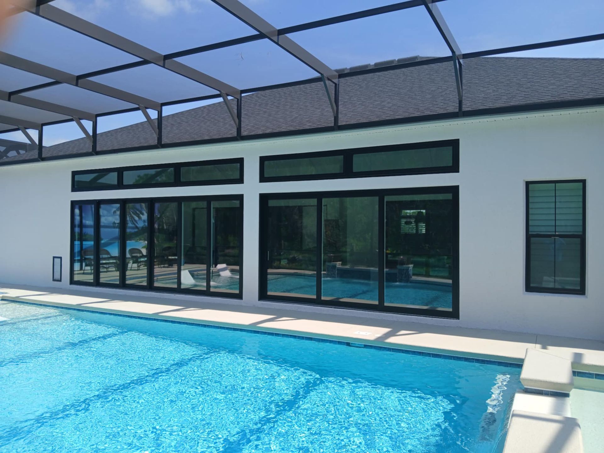 A dining room with a long table and chairs and lots of windows