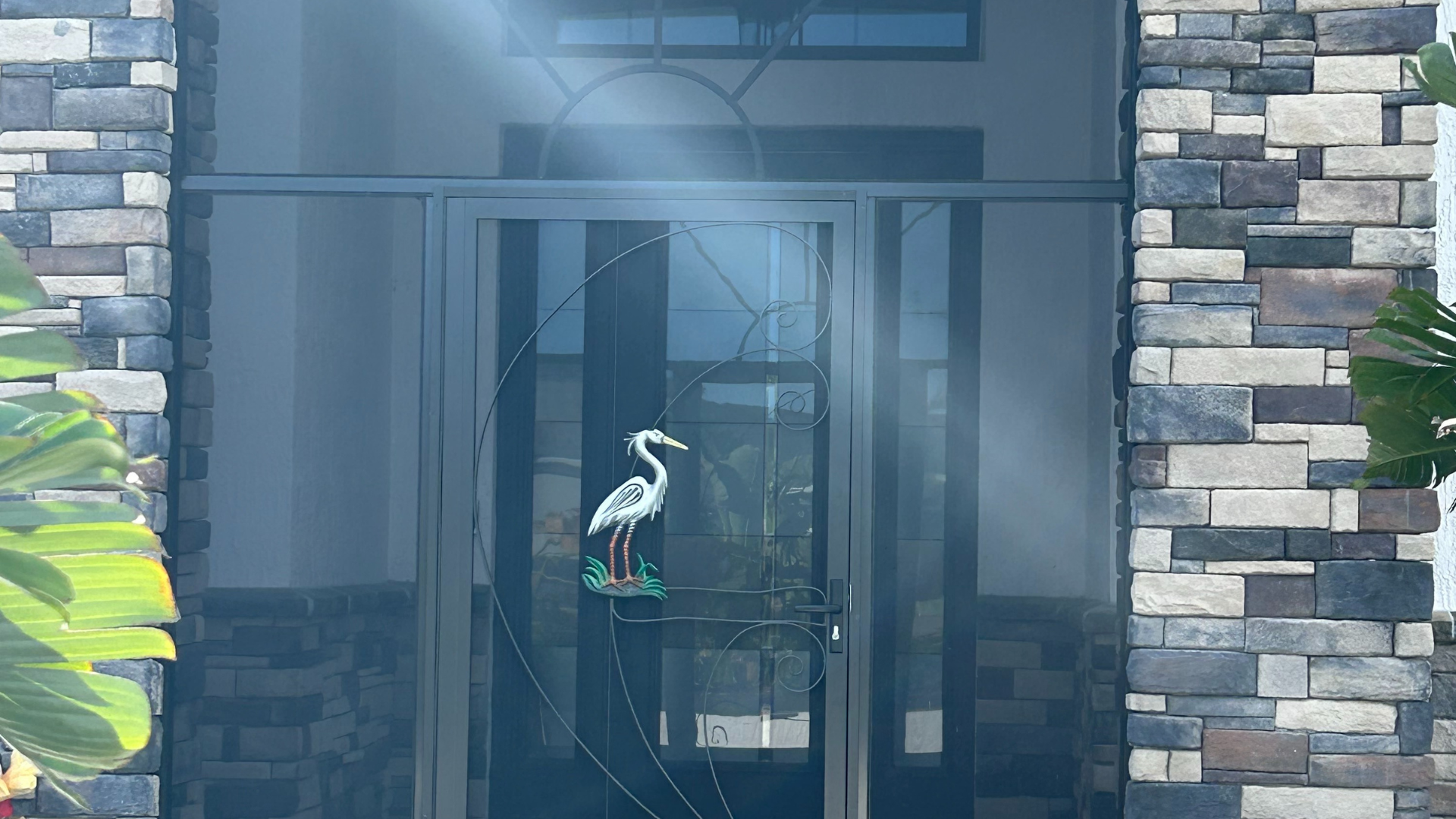 A statue of a bird is in the doorway of a house