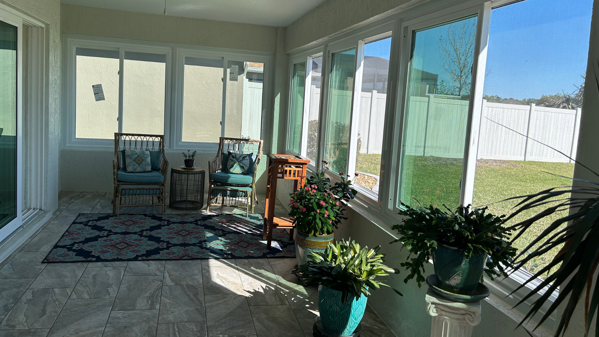 A sun room with lots of windows and plants