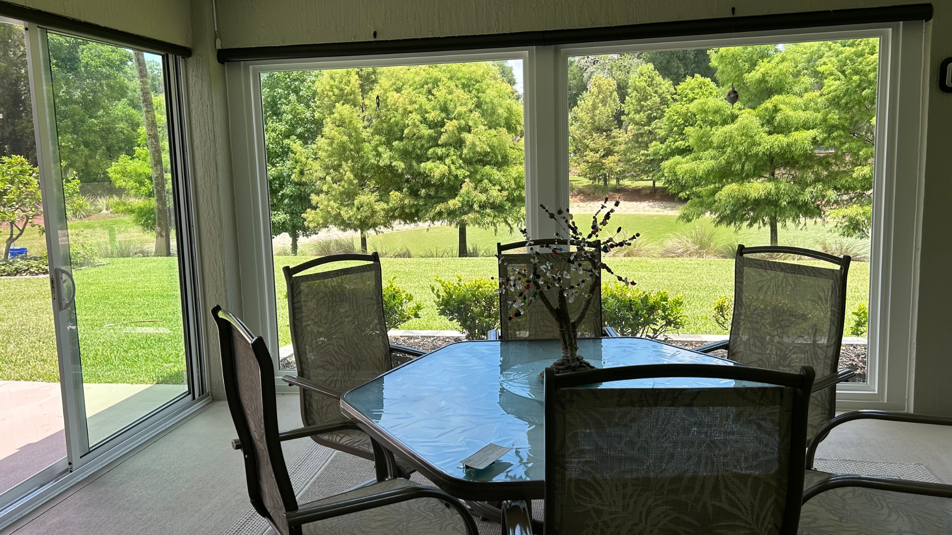 A screened in porch with a table and chairs