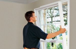 A man is opening a window in a room.