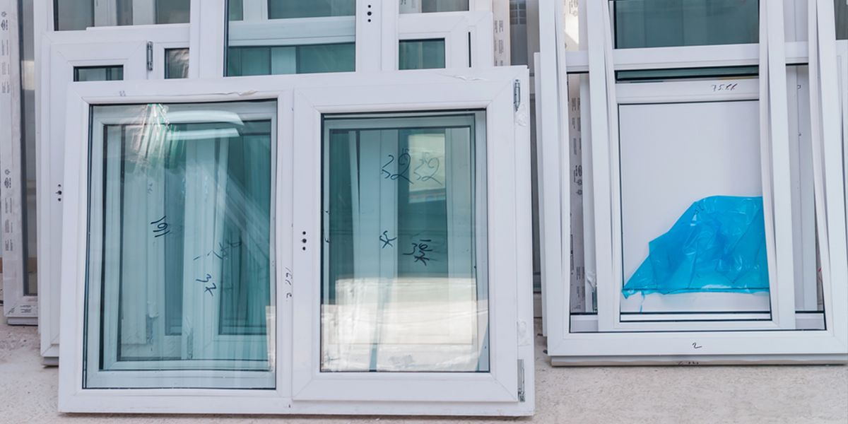 A bunch of windows are stacked on top of each other on a wall.