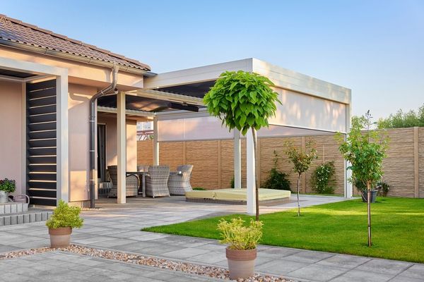 A house with a patio and a pergola in the backyard.