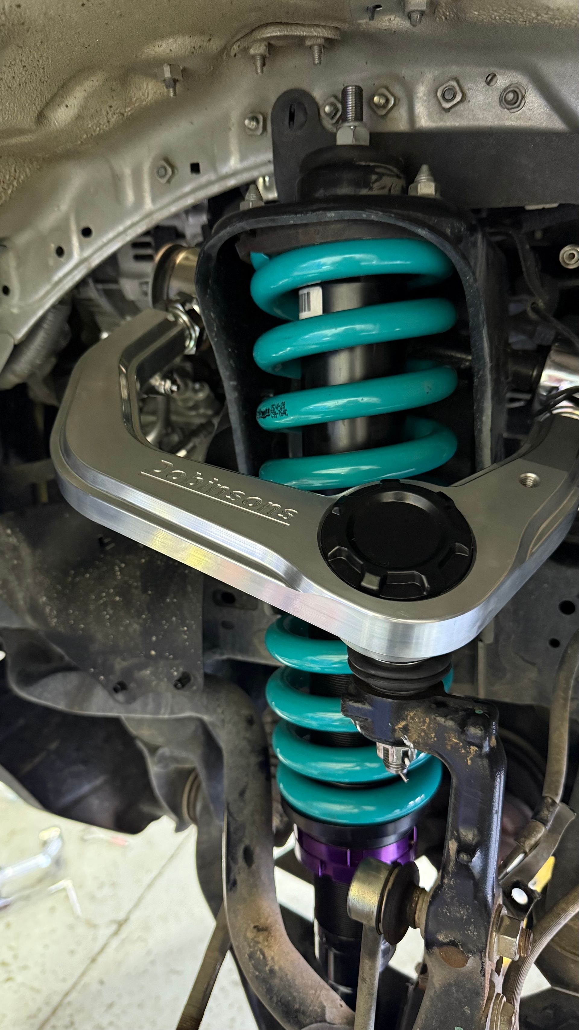 Close-up of a Vehicle Suspension System With a Blue and Yellow Coilover — Atlas 4X4 Touring & Mechanical in Tweed Heads, NSW