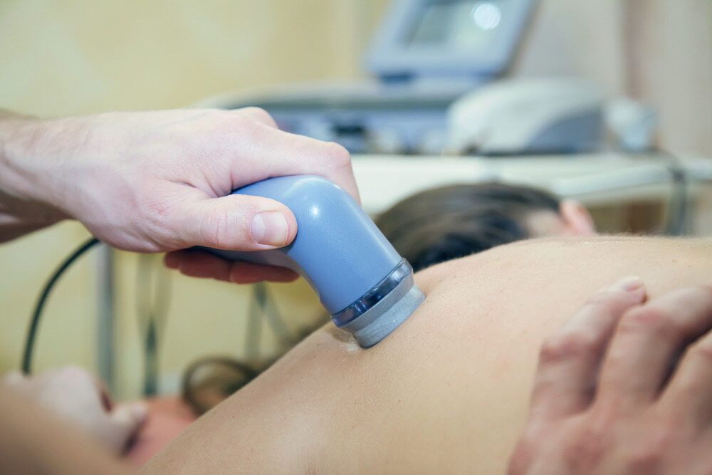 A Person Is Using An Ultrasound Machine On A Woman's Back — Southern Districts Physiotherapy & Sports Injuries Clinic In Albion Park, NSW