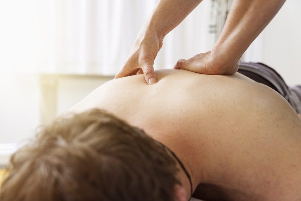 A Man Is Getting A Massage From A Woman — Southern Districts Physiotherapy & Sports Injuries Clinic In Albion Park, NSW
