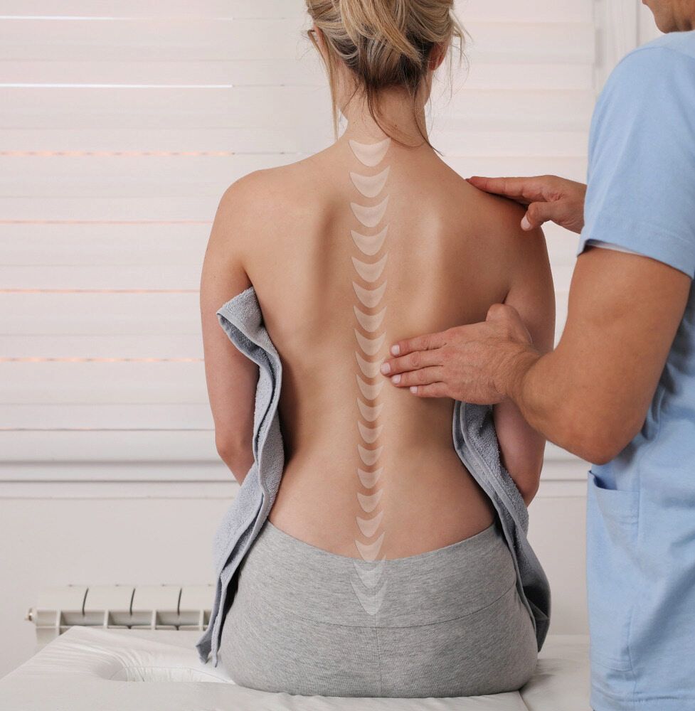 A Woman Is Getting Her Back Examined By A Doctor — Southern Districts Physiotherapy & Sports Injuries Clinic In Albion Park, NSW