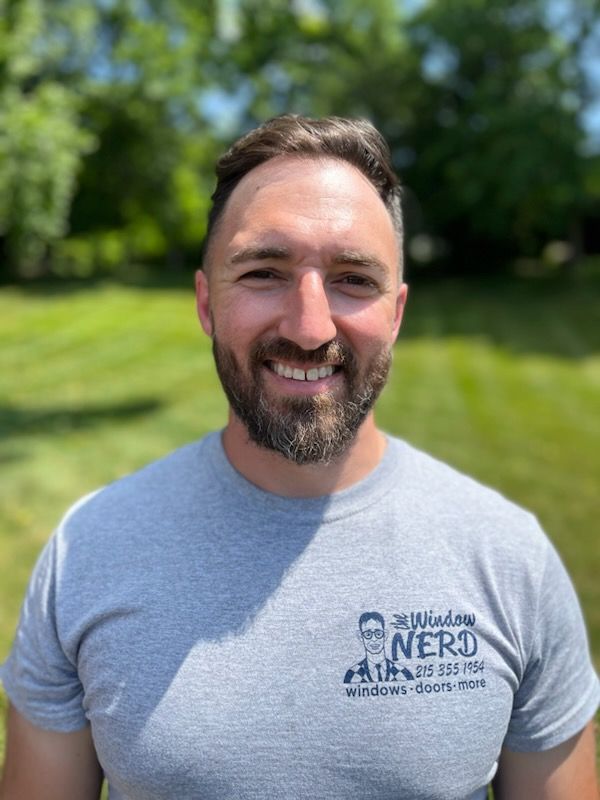 A man with a beard is wearing a window nerds t-shirt and smiling in Doylestown, PA.