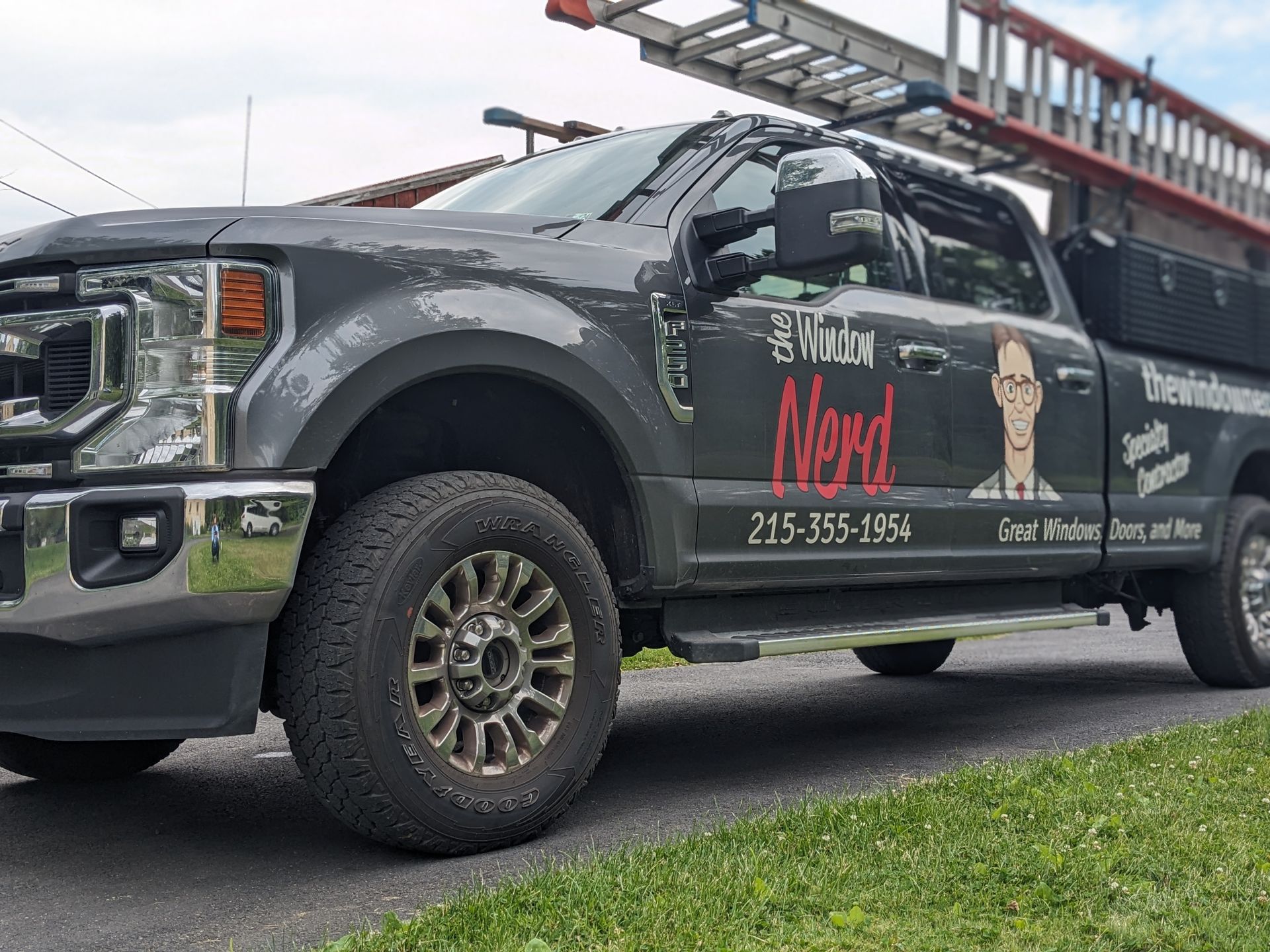 A black truck with the word nerd on the side is parked on the side of the road.