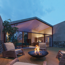 Uma fogueira fica na frente de uma casa grande