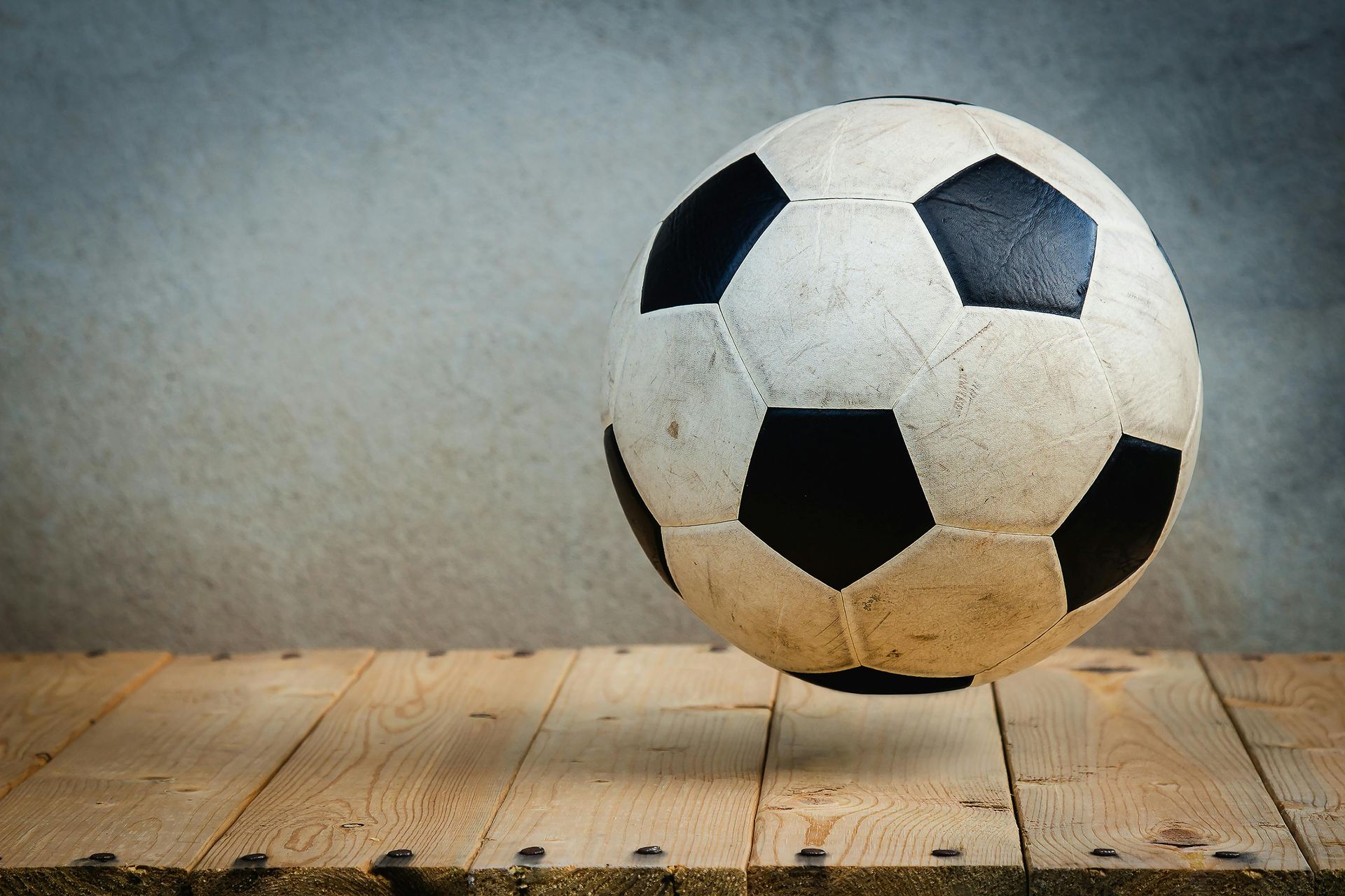 A soccer ball is sitting on a wooden table.