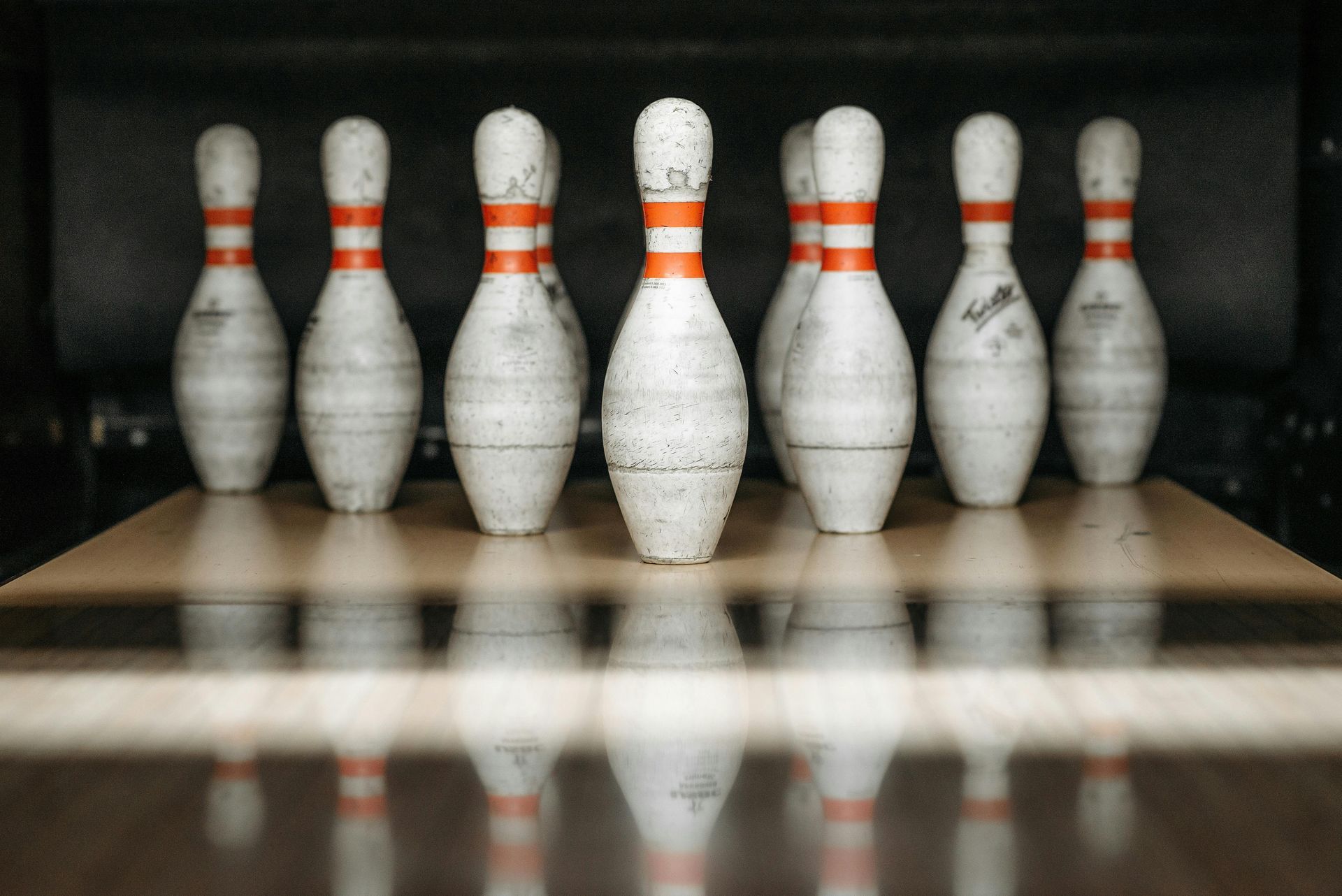A row of bowling pins sitting on top of a wooden table.