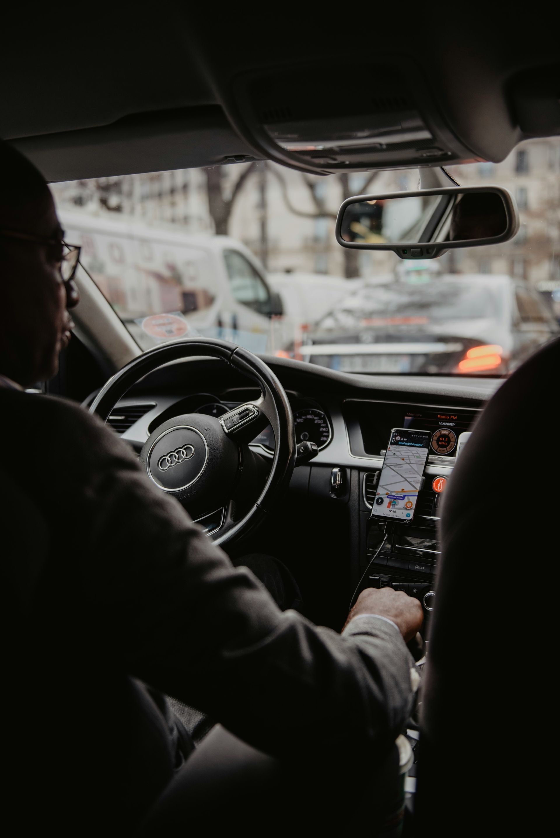 A man is sitting in the driver 's seat of a car.