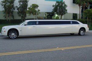 A white limousine is parked on the side of the road.