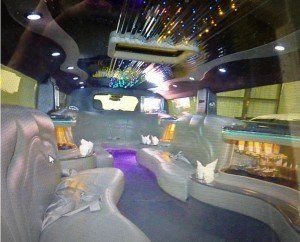 The inside of a limousine with purple lights on the ceiling