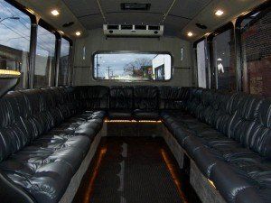 The inside of a bus with a lot of black leather seats