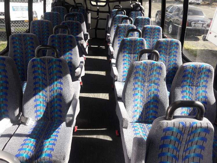 The inside of a bus with blue and gray seats