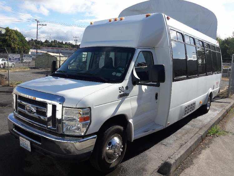 A white bus is parked on the side of the road.