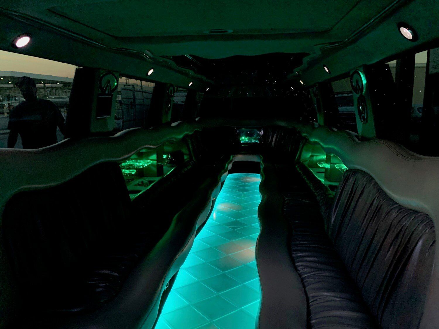 The inside of a limousine with green lights on the floor.