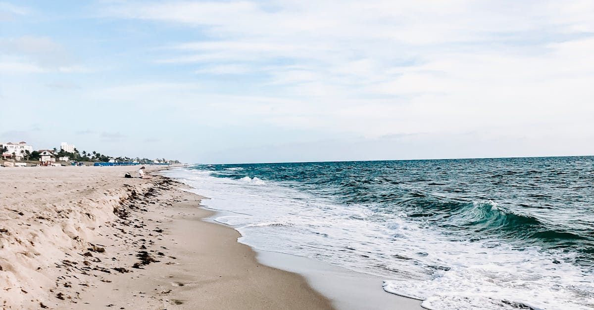 A beach with waves crashing against the shore on a sunny day.