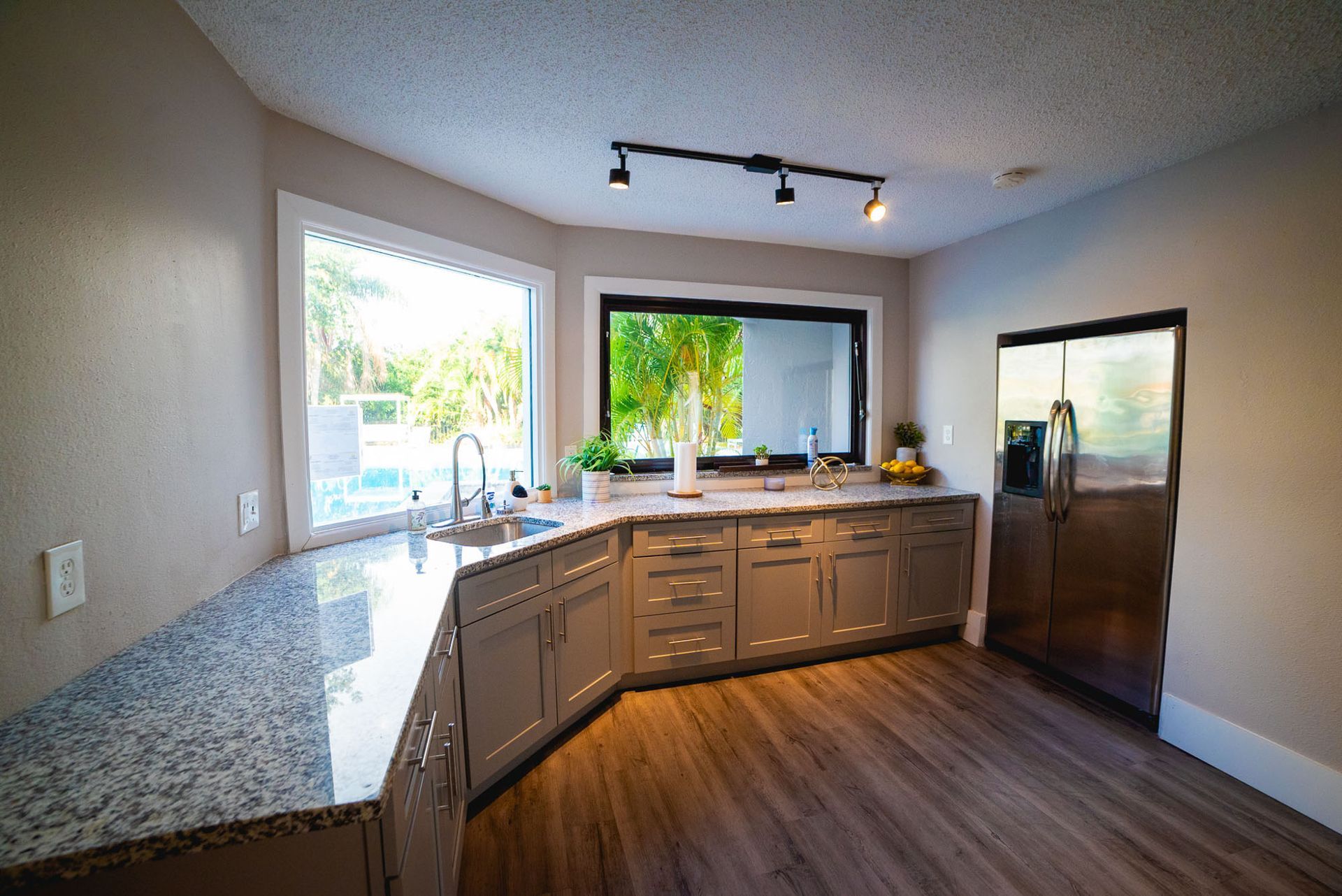 A kitchen with granite counter tops , stainless steel appliances , and a large window at Trellis at The Lakes.