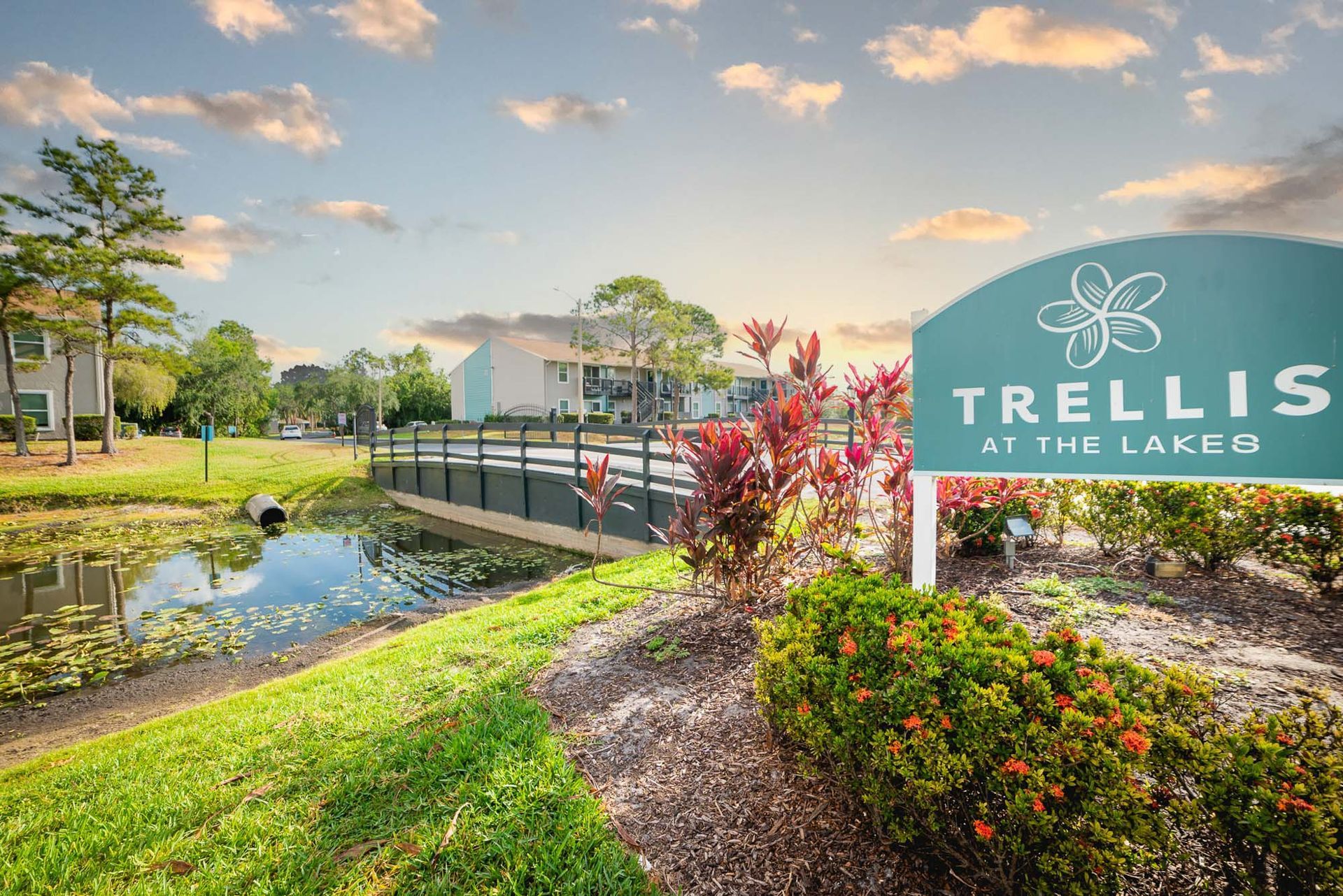 A sign for trellis at the lake is in front of a pond at Trellis at The Lakes.