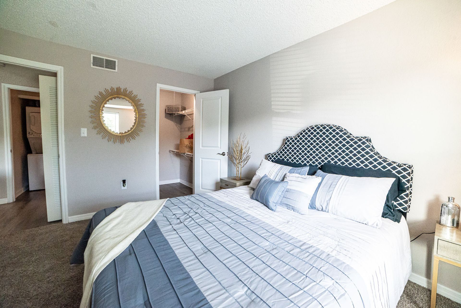 A bedroom with a large bed and a mirror on the wall at Trellis at The Lakes.
