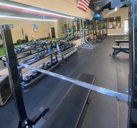 A group of people are sitting on benches in a gym.