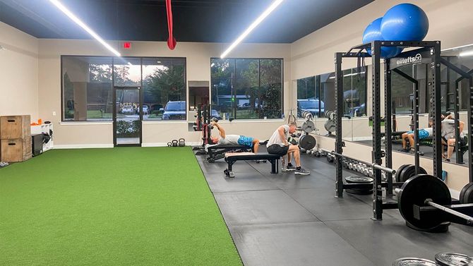A group of people are sitting on benches in a gym.